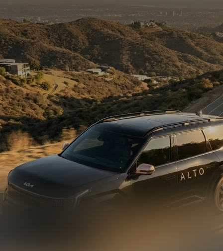 An Alto vehicle on a hillside road at dusk